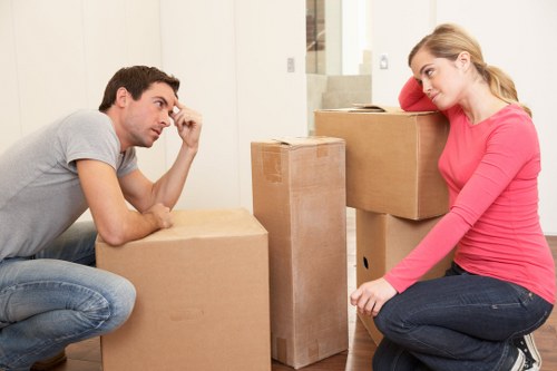 Removal van and movers handling furniture in an East London street